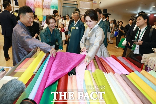 영부인 김혜경 여사가 14일 서울 동대문디자인플라자(DDP)에서 열린 '2026 한복상점'을 찾아 원단을 살펴보고 있다. /뉴시스