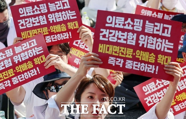 대한약사회 회원들이 지난 20일 서울 종로구 동화면세점 앞에서 열린 국민건강·건강보험 수호 전국 약사 총궐기대회에서 구호를 외치고 있다. /뉴시스