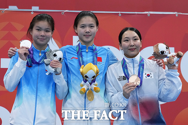 금메달리스트인 중국의 린산(가운데), 은메달리스트인 중국의 롱이핑(왼쪽), 동메달리스트인 한국의 김수지가 아시안게임 여자 1m 스프링보드 결승 시상식에서 메달을 들고 포즈를 취하고 있다. /도쿄=AP.뉴시스
